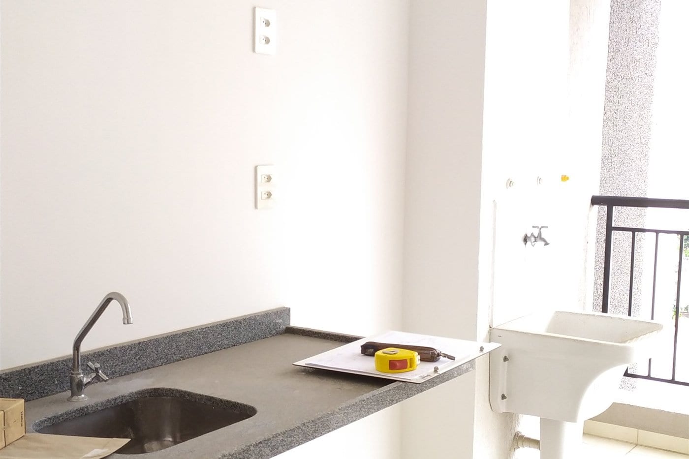 Vila Mariana antes: a cozinha com a bancada e o piso entregues pela construtora.