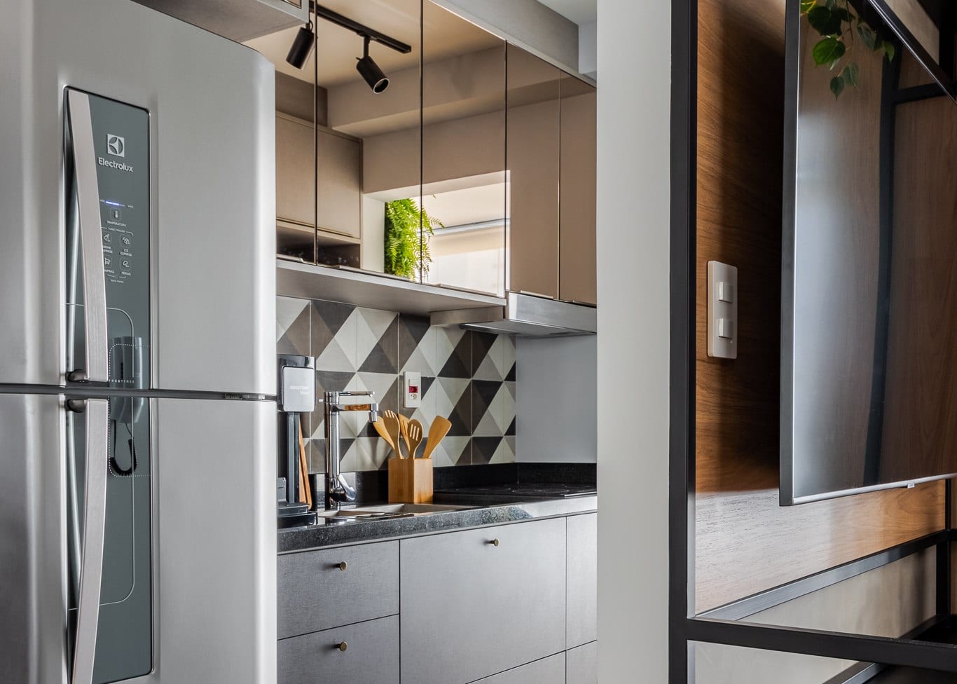 Vila Mariana: a cozinha integrada com backsplash geometrico e marcenaria amadeirada, foto Alberto Ricci