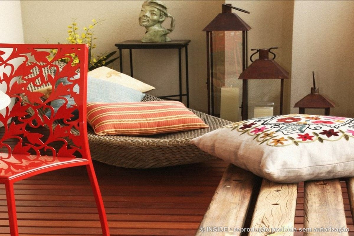 Varanda decorada com cadeira vermelha, almofadas bordadas e lanternas - tudo transportável, projeto INSIDE
