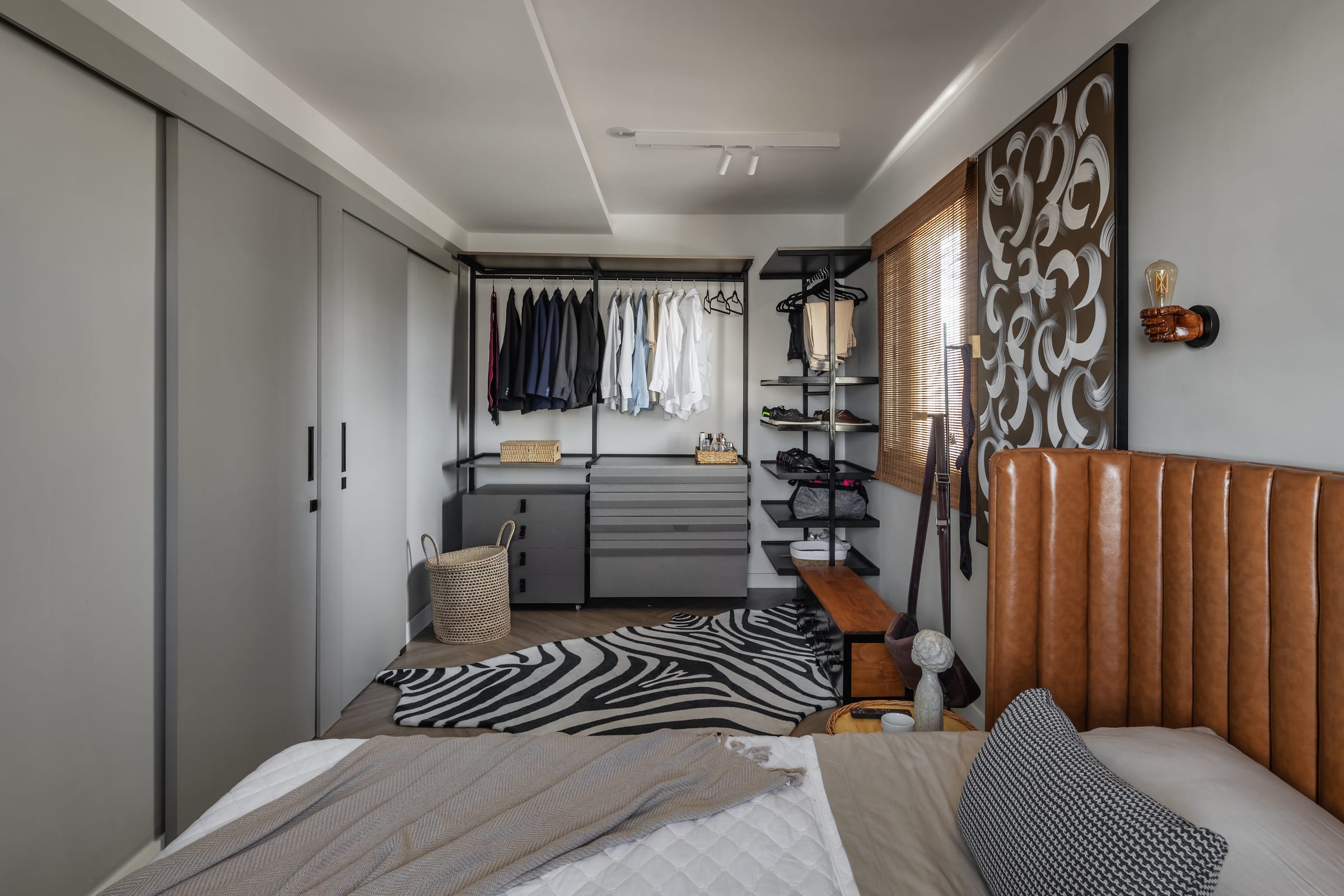 Suíte do casal com cabeceira de couro caramelo, closet aberto e tapete zebra, projeto INSIDE