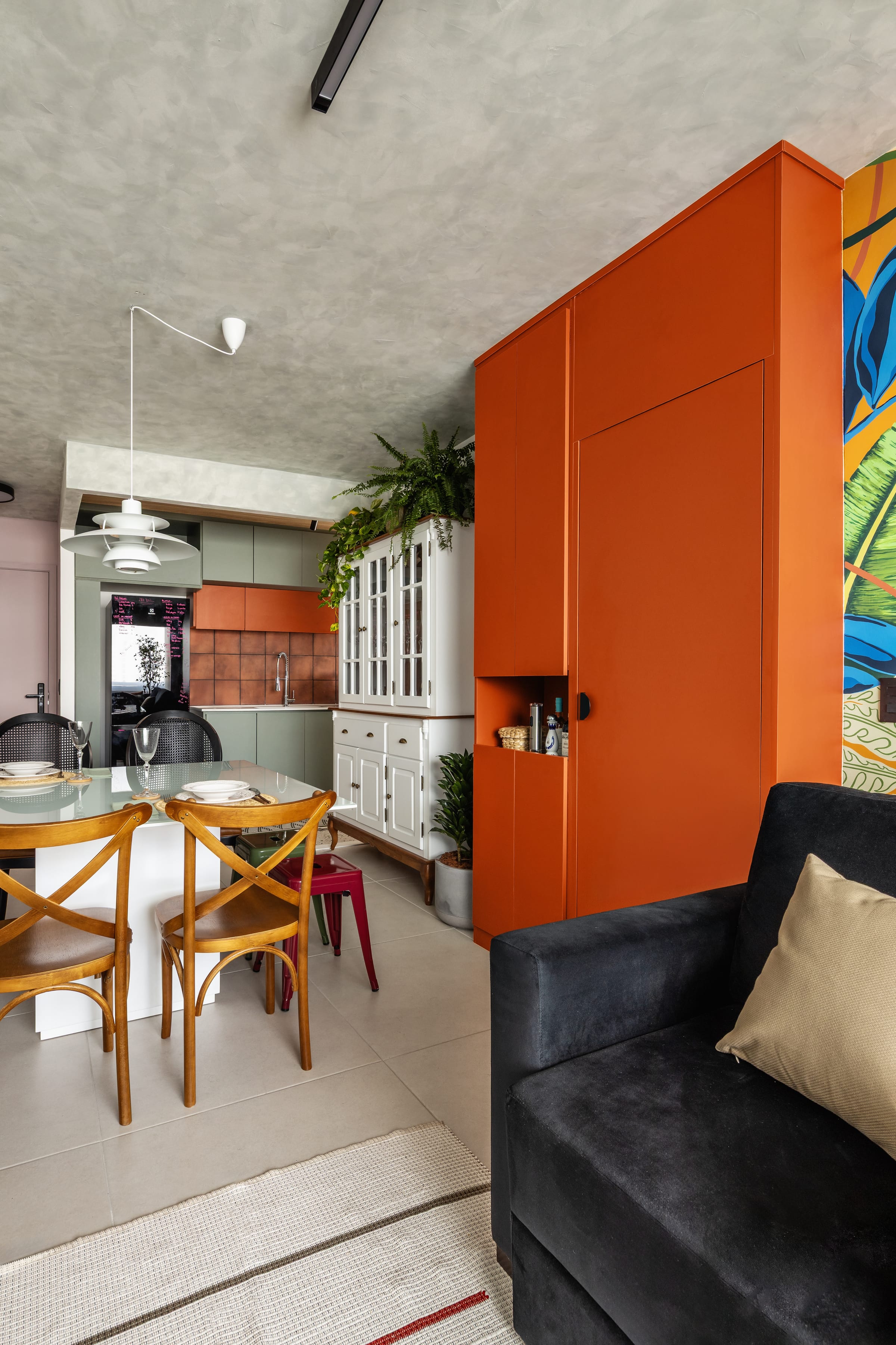 Cozinha e sala integradas com marcenaria laranja, mural tropical de folhagens, cozinha verde e teto de concreto, projeto INSIDE
