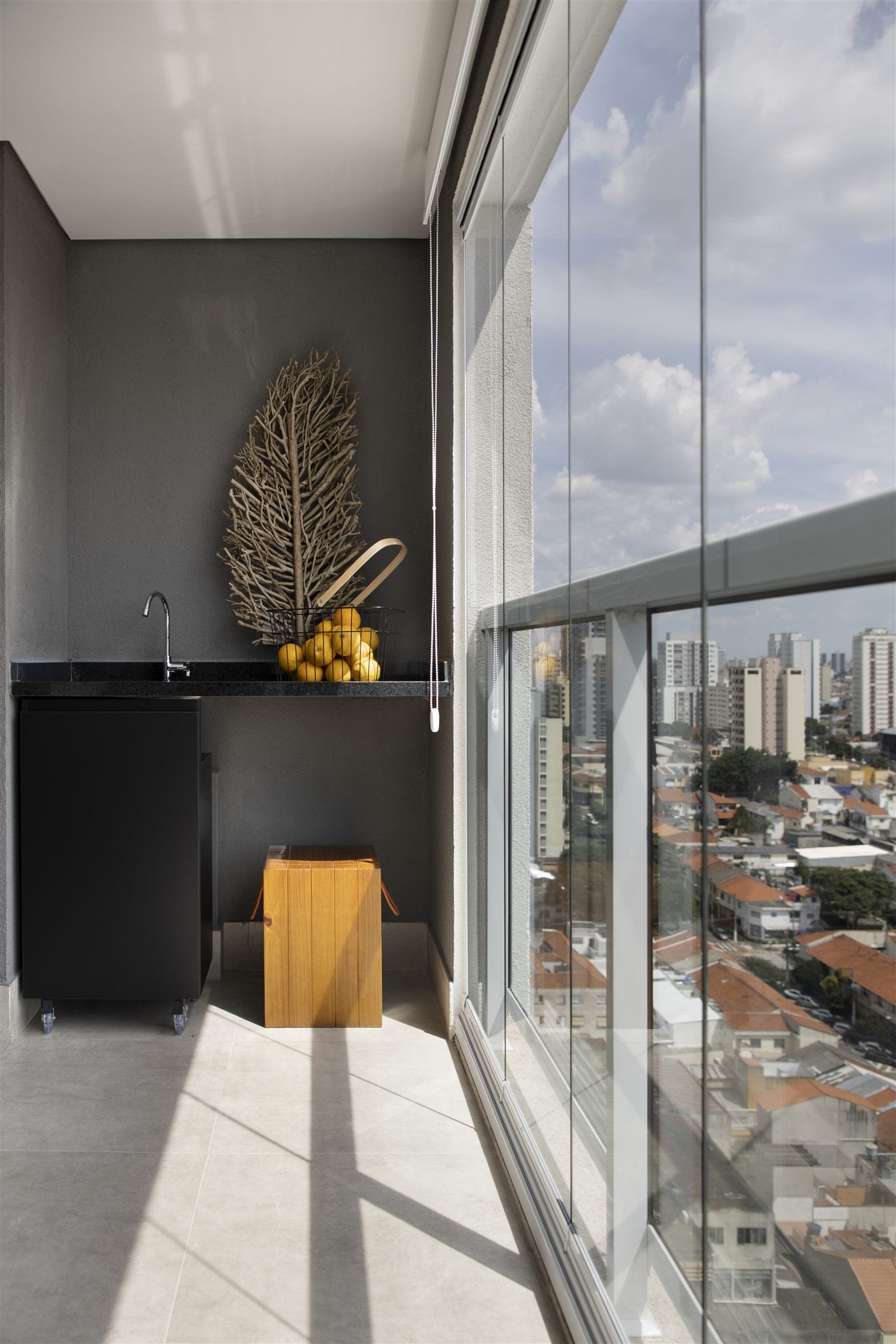 A varanda com o gabinete volante e a vista da cidade pelo fechamento de vidro, apartamento alugado, projeto INSIDE