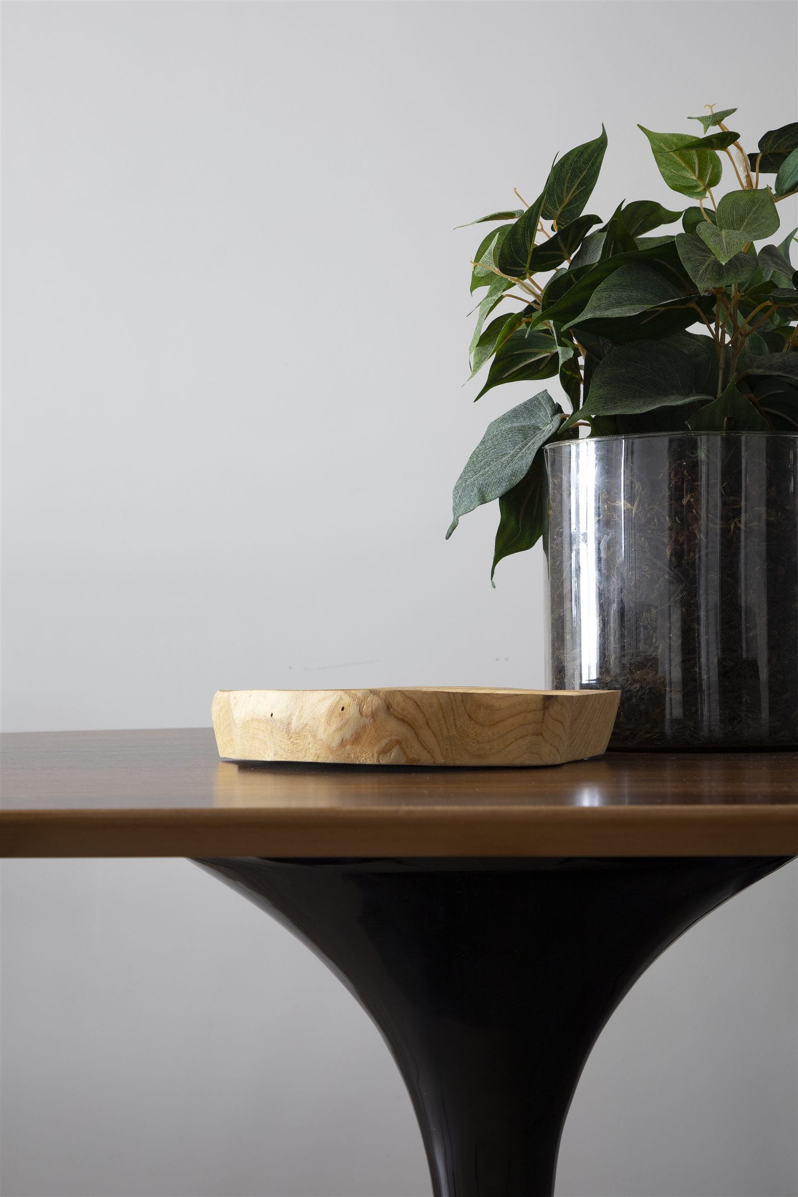 Detalhe sobre a mesa de jantar Saarinen, com vaso metálico e planta, apartamento alugado, projeto INSIDE