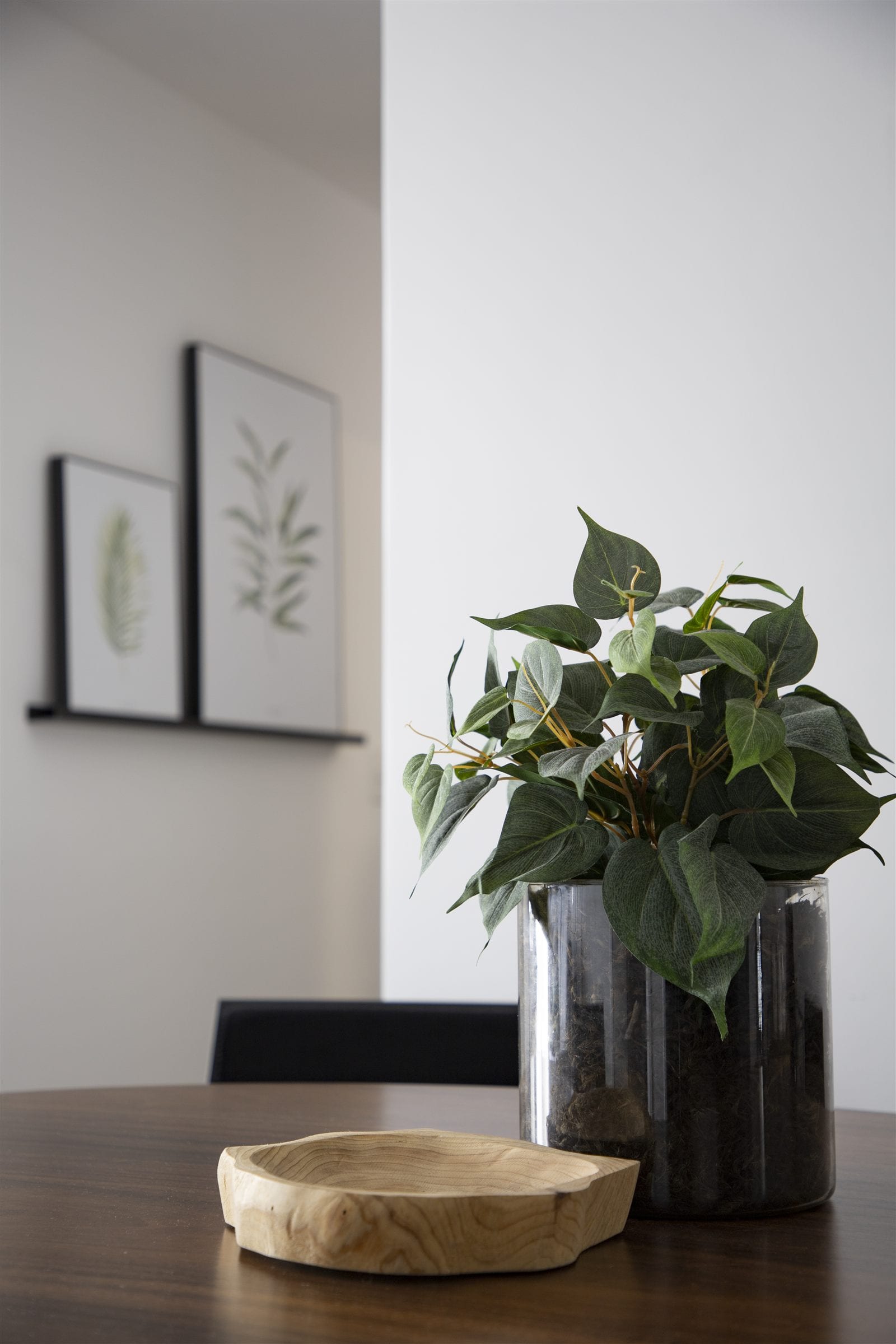 Detalhe decorativo com quadros botânicos e vaso metálico com folhagem, projeto INSIDE