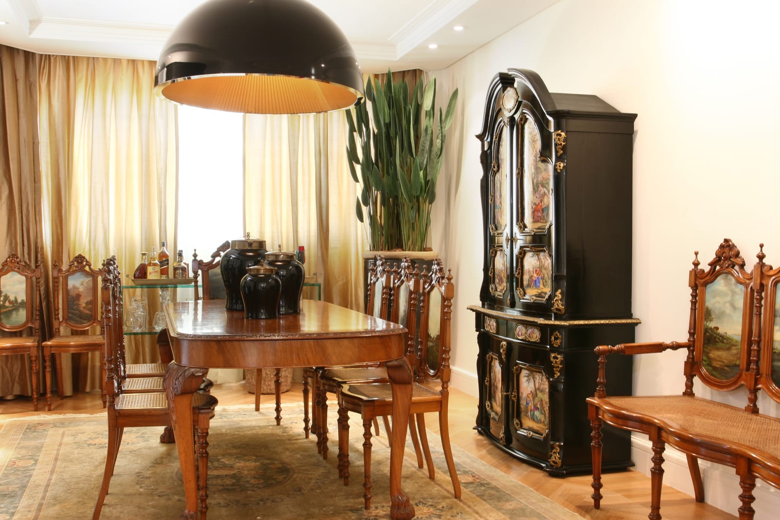 Sala de jantar com cadeiras antigas de medalhão sob pendente contemporânea preta, projeto INSIDE