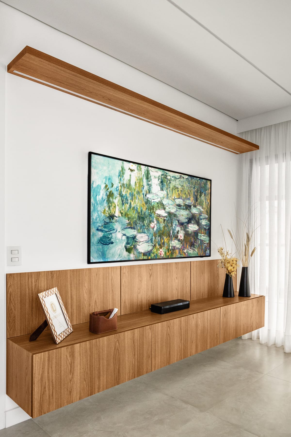 Quadro emoldurado sobre aparador de madeira na casa acompanhada do projeto Paraíso-YK, INSIDE