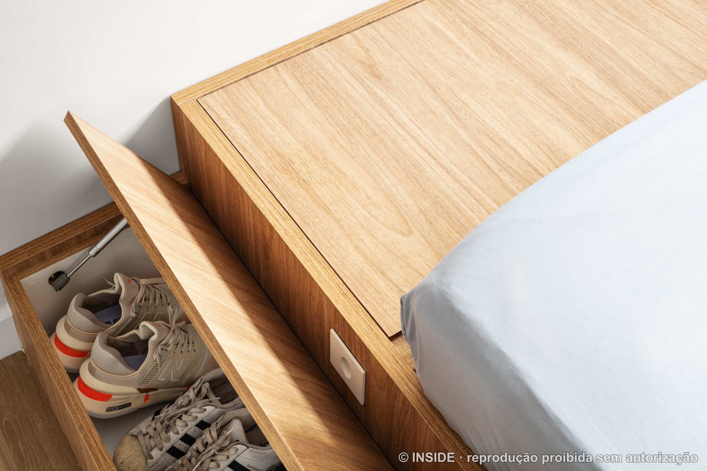 Detalhe da cama retrátil dobrável embutida na marcenaria de madeira, projeto INSIDE