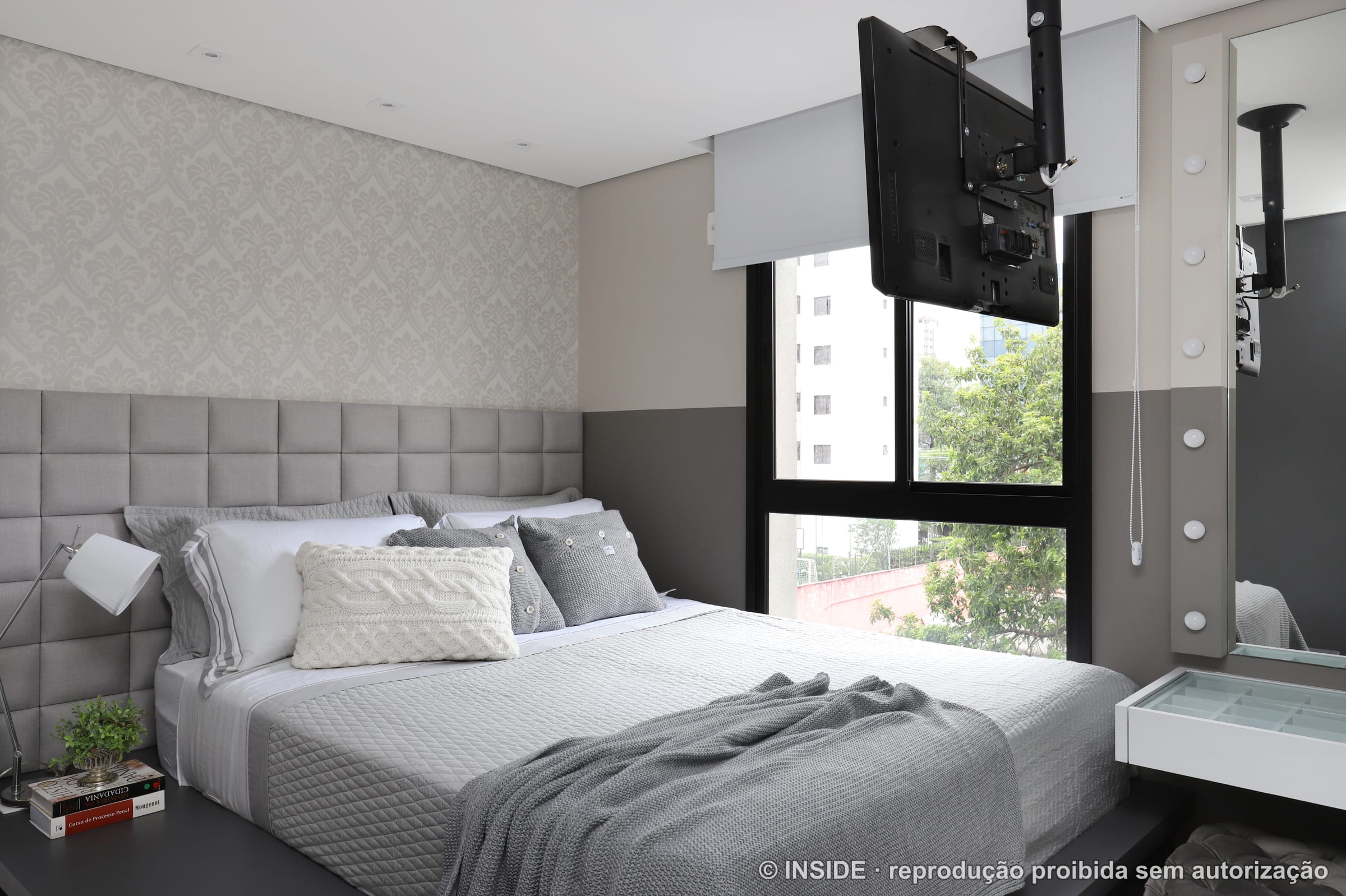 Cama de casal junto à janela com vista para a cidade, cabeceira estofada e criado suspenso, projeto INSIDE