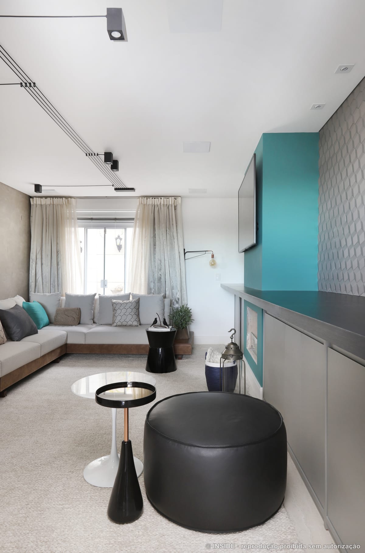 Sala de estar com parede em turquesa, lareira embutida e sofá claro, janela ampla, projeto INSIDE
