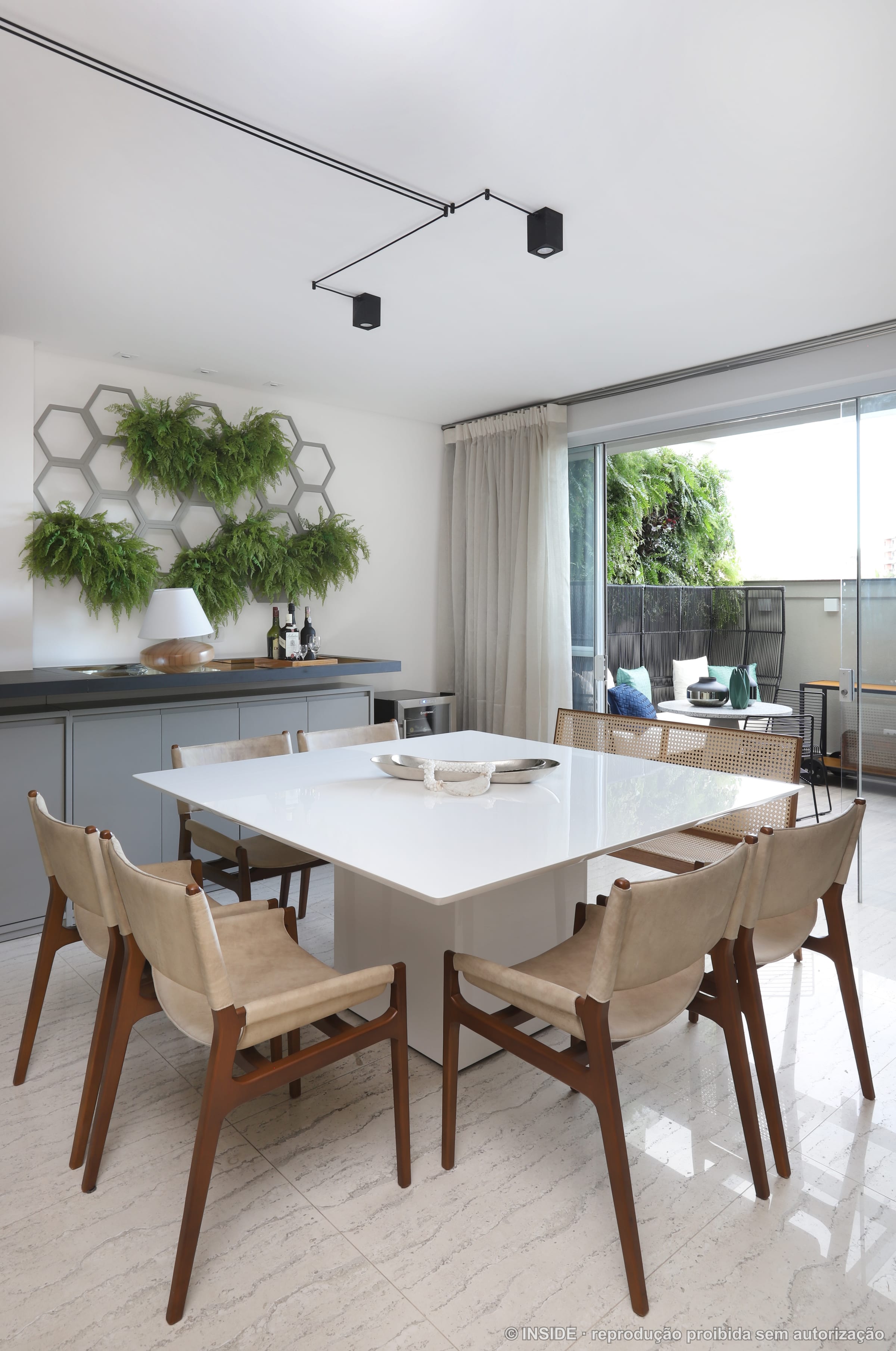 Sala de jantar com mesa branca, jardim vertical de samambaias e backsplash hexagonal, projeto INSIDE