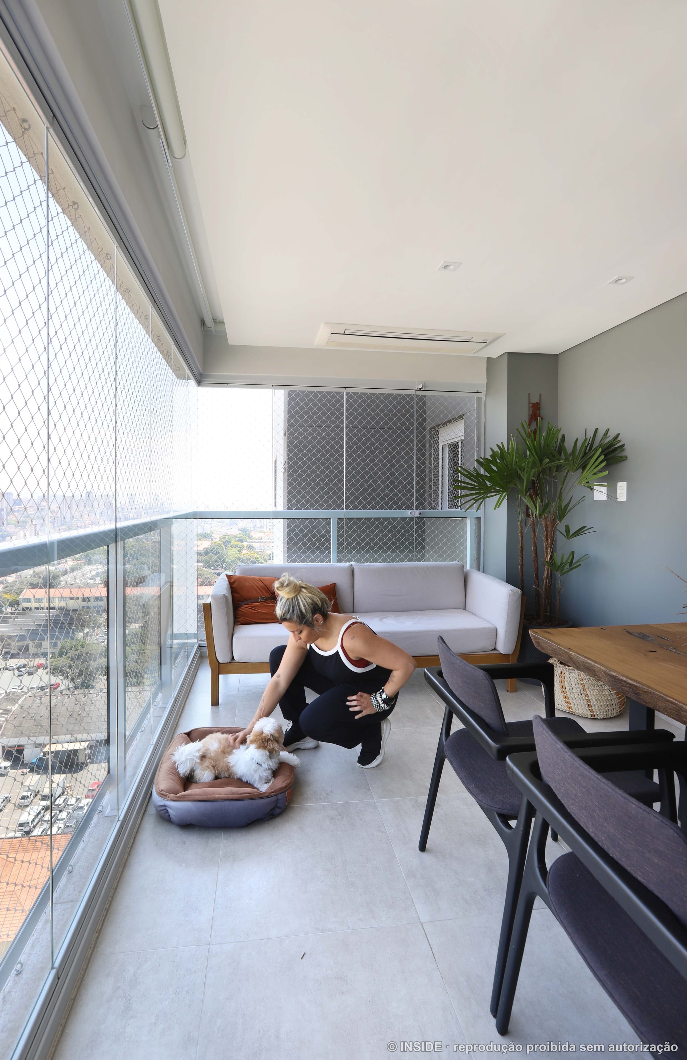 Terraço gourmet envidraçado com bancada, banquetas e vista do skyline de São Paulo, projeto INSIDE