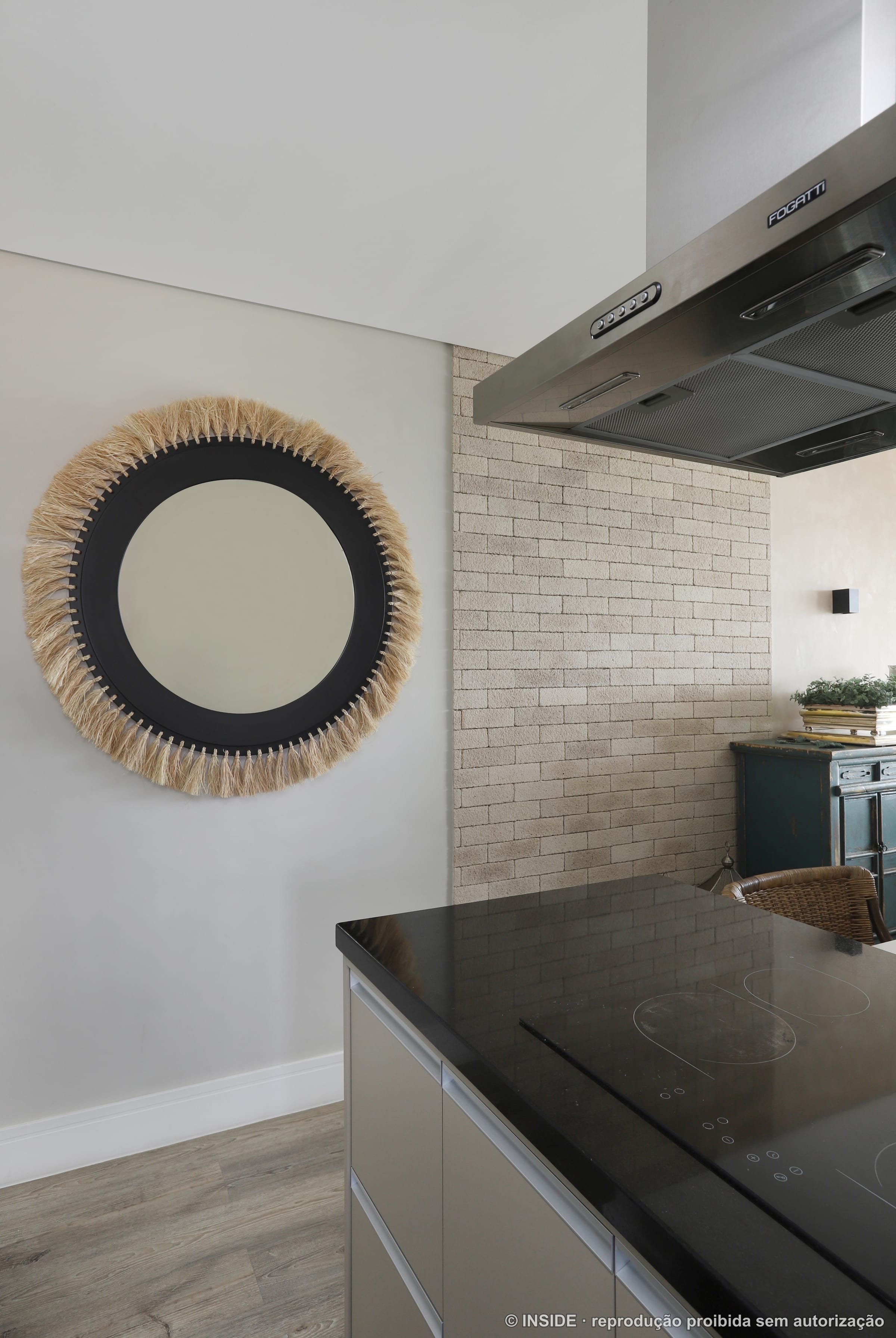 Cozinha com azulejo de metrô branco, espelho redondo de palha e acento turquesa, projeto INSIDE