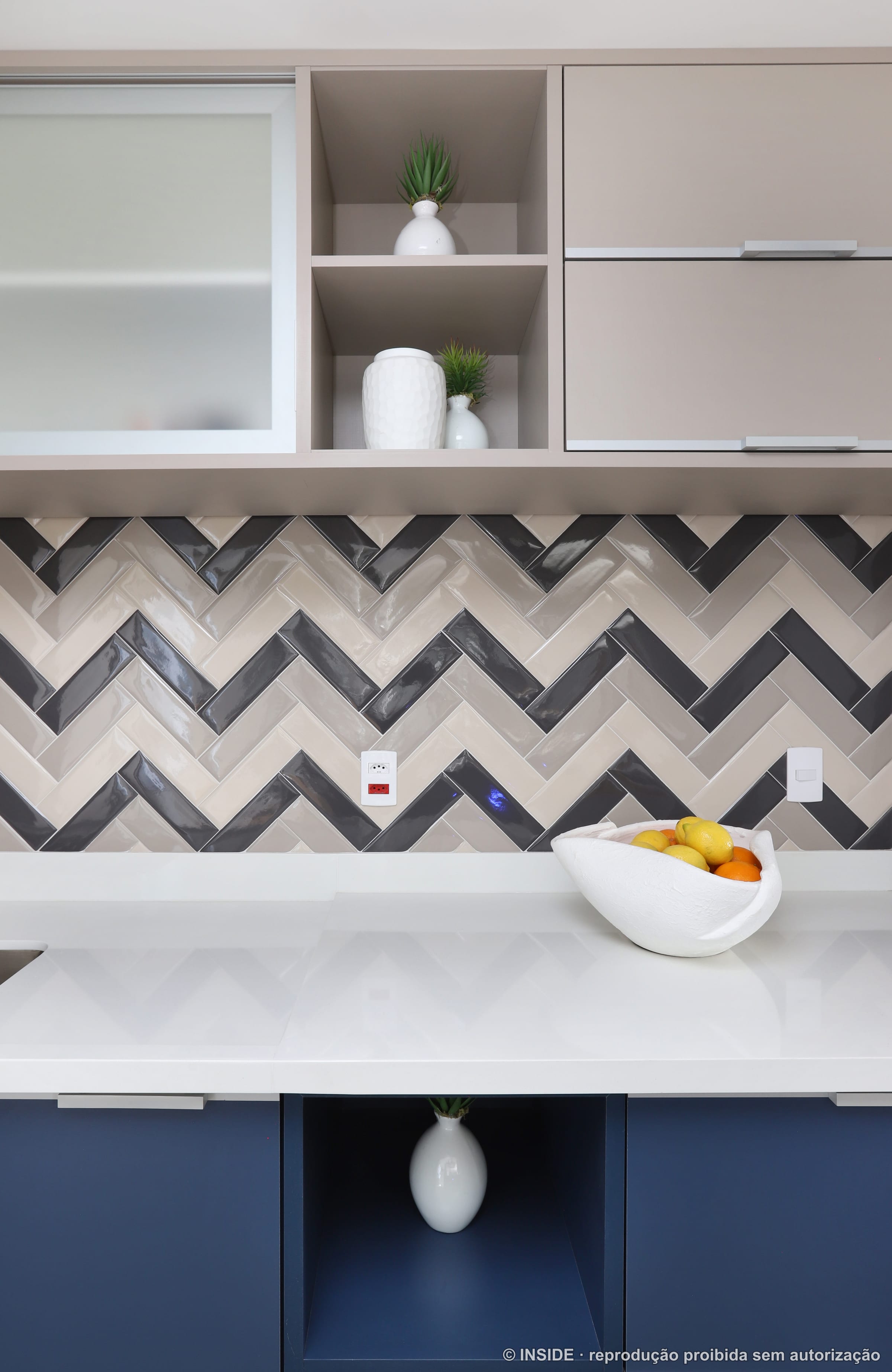 Cozinha com armários em azul-marinho, bancada branca e backsplash em mosaico espinha de peixe preto e branco, projeto INSIDE