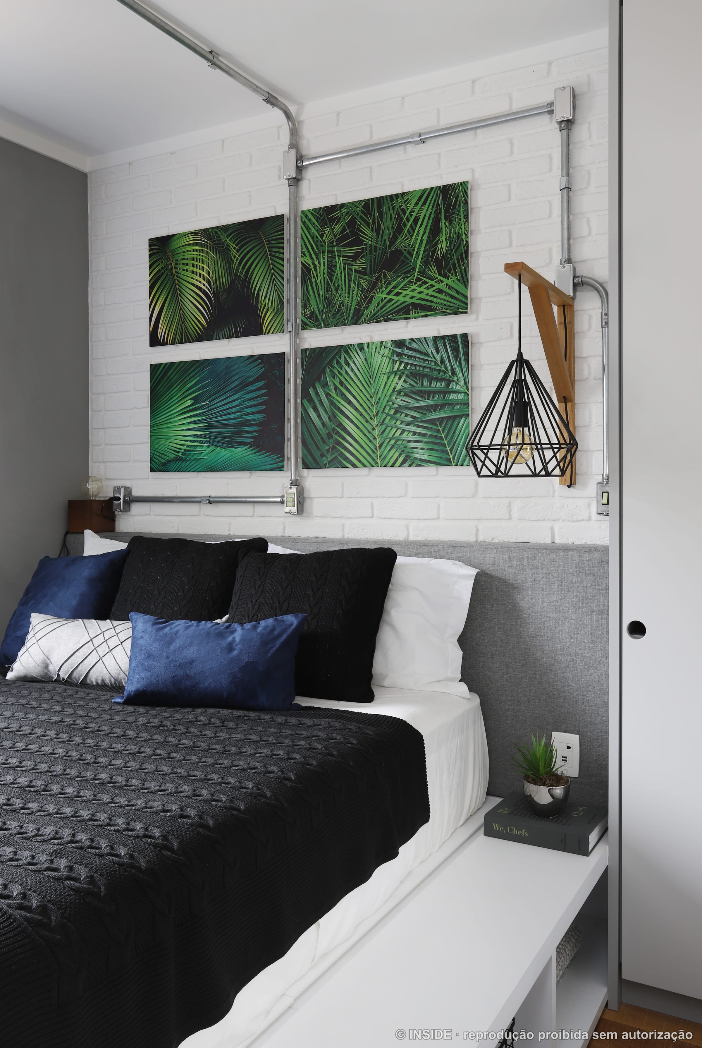 Quarto de casal com arte de folhagem tropical, pendente geométrico preto e cama clara, projeto INSIDE