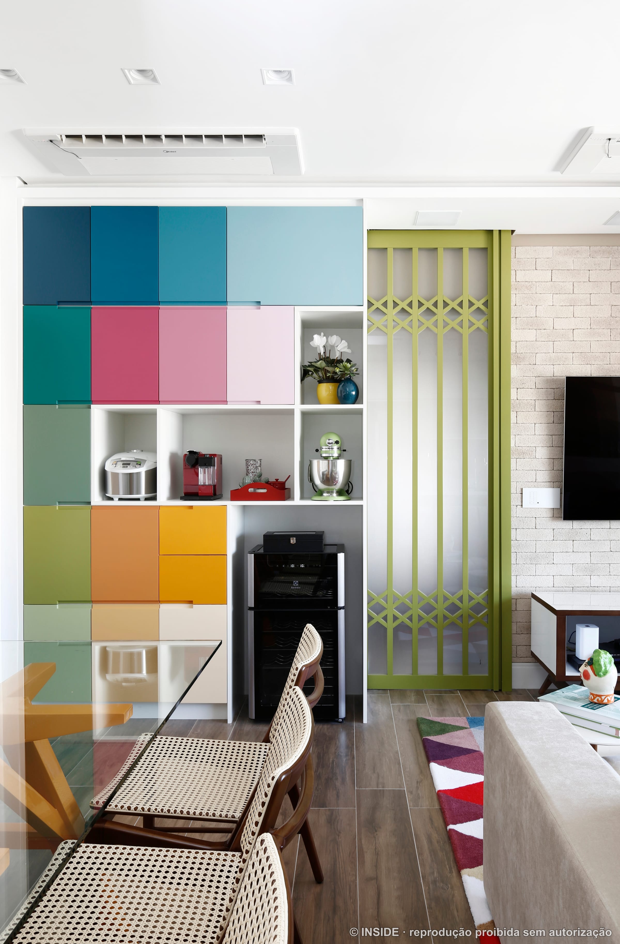 Estante modular com nichos em azul, verde, laranja e lilás ao lado do sofá, projeto INSIDE