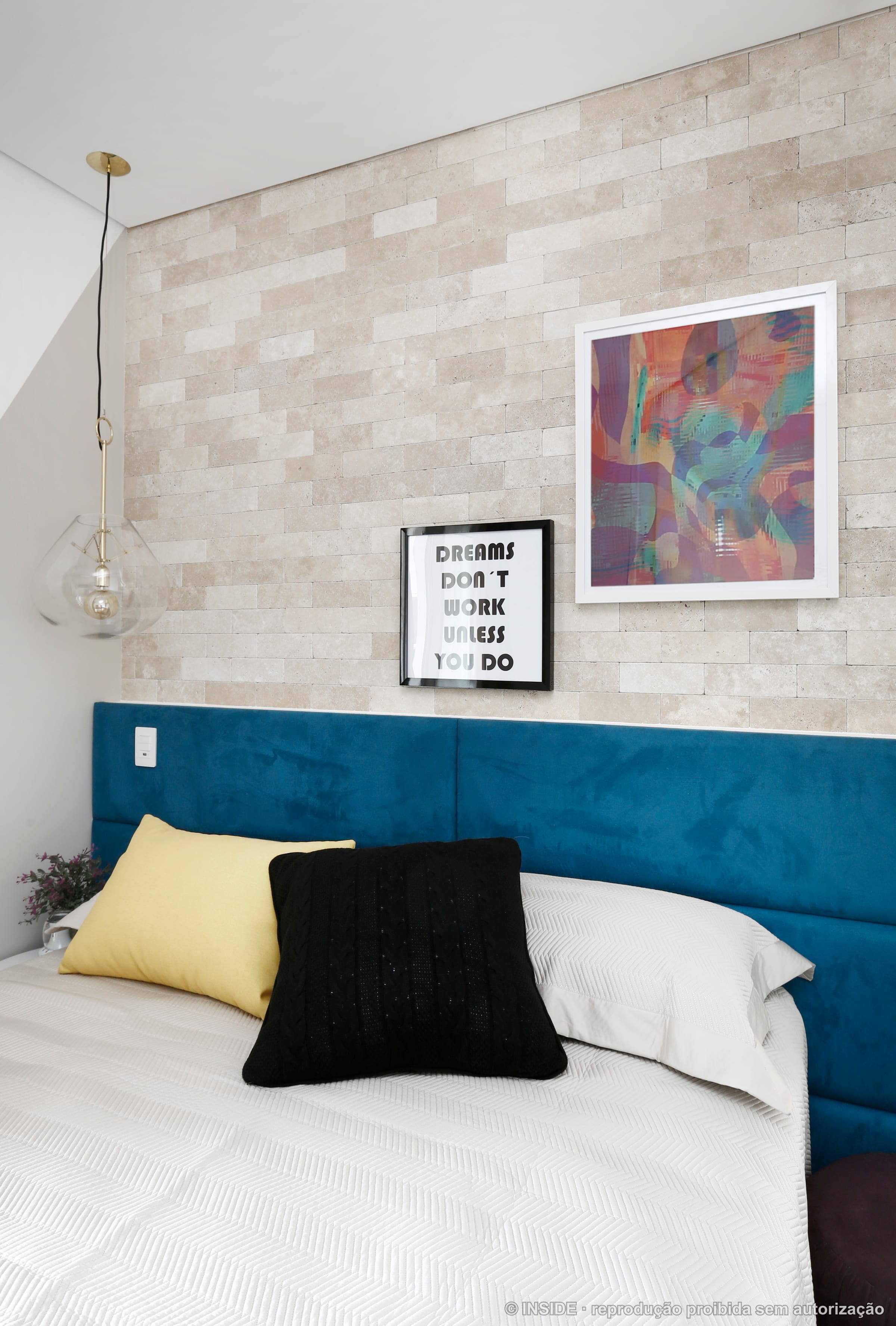 Quarto de casal com cabeceira estofada em azul petróleo, roupa de cama clara e quadro colorido, projeto INSIDE