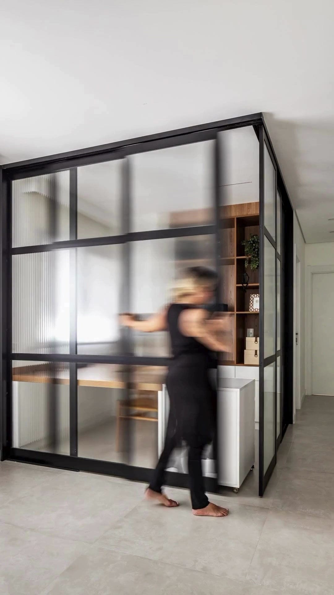 Apartamento INSIDE: sala com caixilho preto, madeira e luz natural